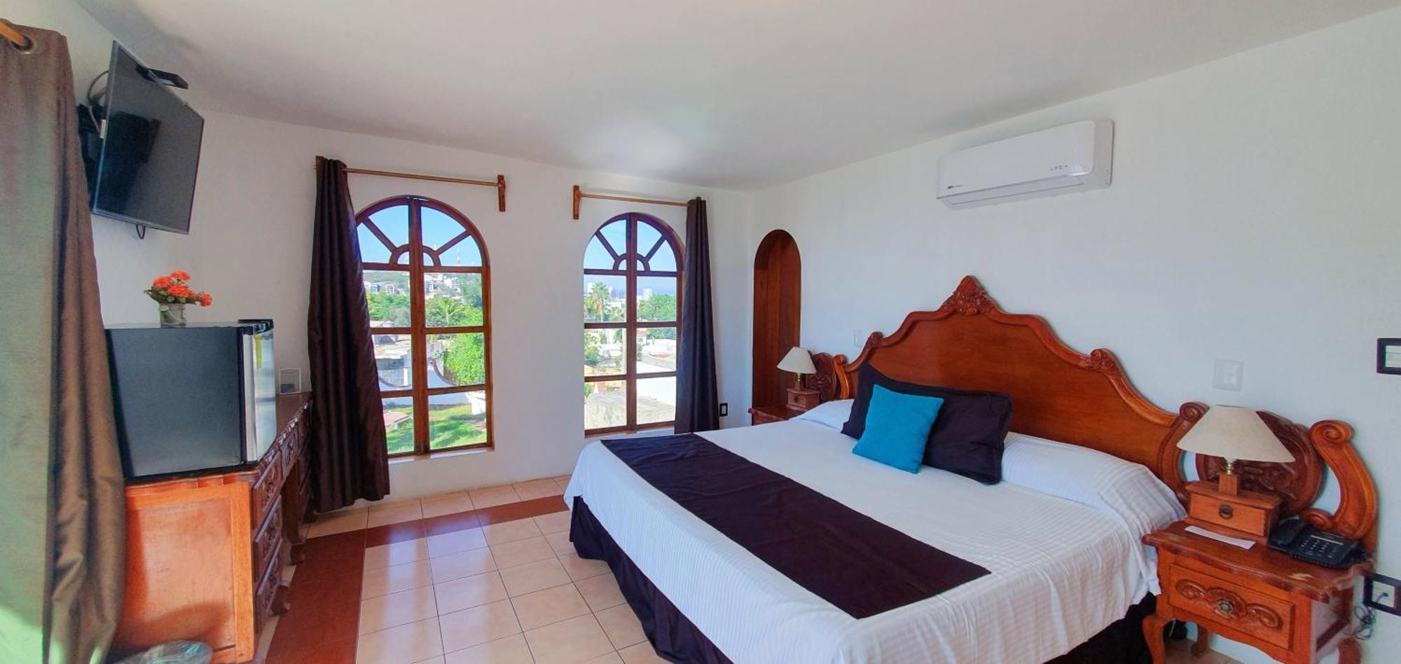Habitación con cama extragrande y vistas a la piscina